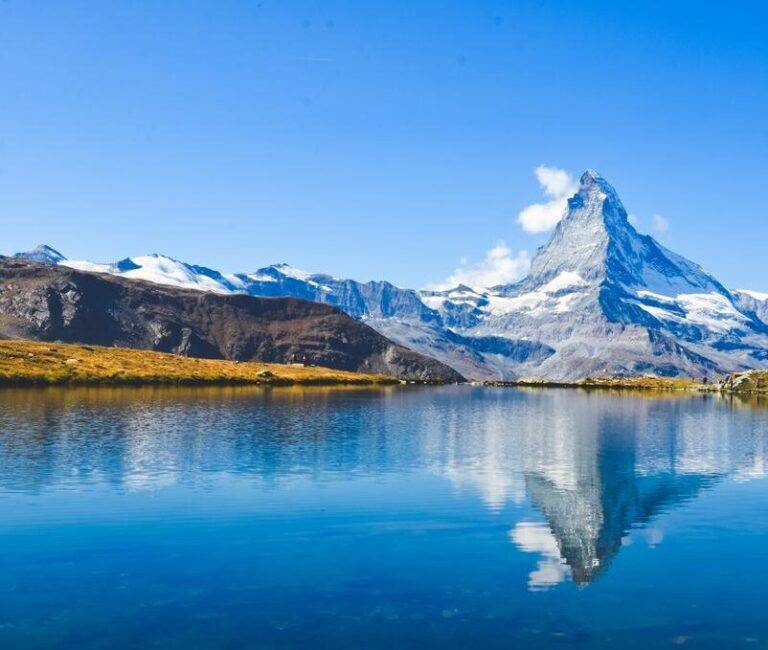 Spiegelung des Matterhorns in einem klaren Bergsee auf der 5-Seen-Wanderung Zermatt bei strahlendem Sonnenschein.